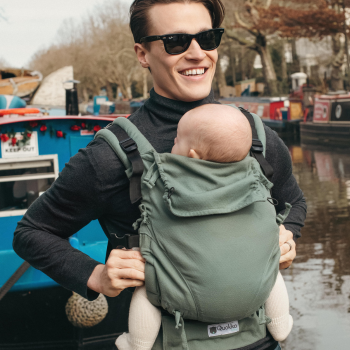 padre porteando en mochila de porteo evolutiva en la que se aprecia con detalle que el panel se ajusta al tamaño exacto del bebé